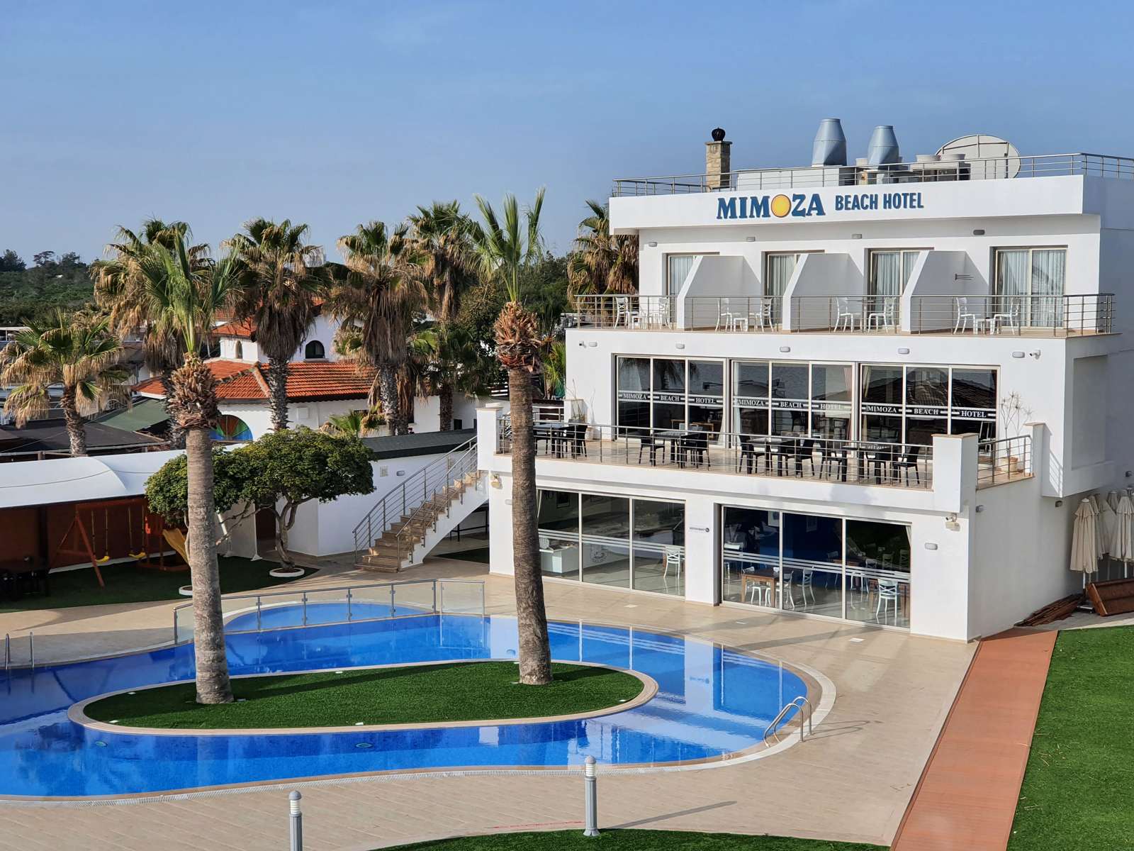 Mimoza Beach Hotel mit den zwei charakteristischen Palmen auf der Poolinsel - Lupe Reisen